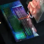 Ultraskin optics chip - Optical chip developed in the study with laser light from an optical fiber array. Credit: Jake Freedman